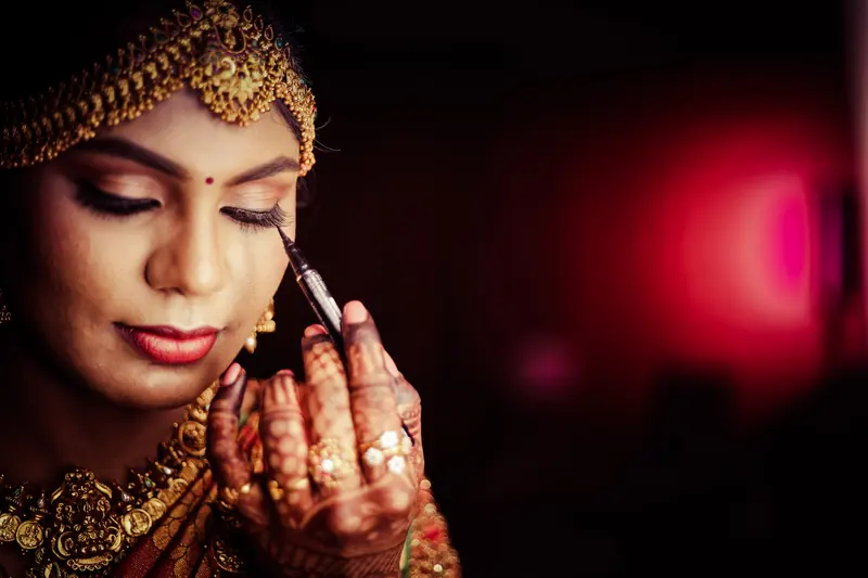 Bride applying eyeliner while getting ready on her wedding day