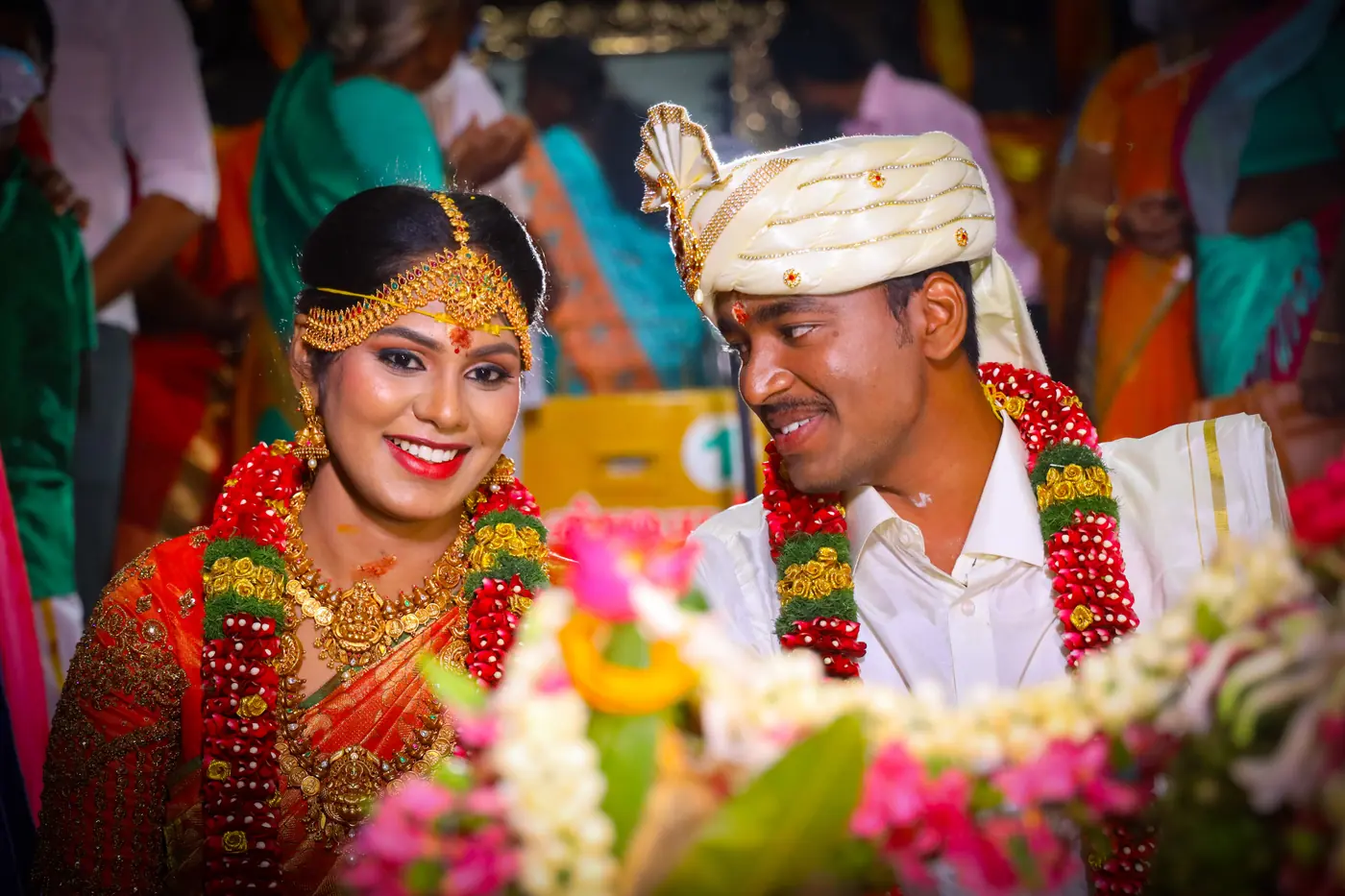 Bride and groom smiling in flower garlands at their Tamil wedding